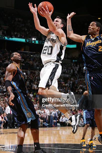 Manu Ginobili of the San Antonio Spurs goes to the basket against Nene and Marcus Camby of the Denver Nuggets in Game Two of the Western Conference...