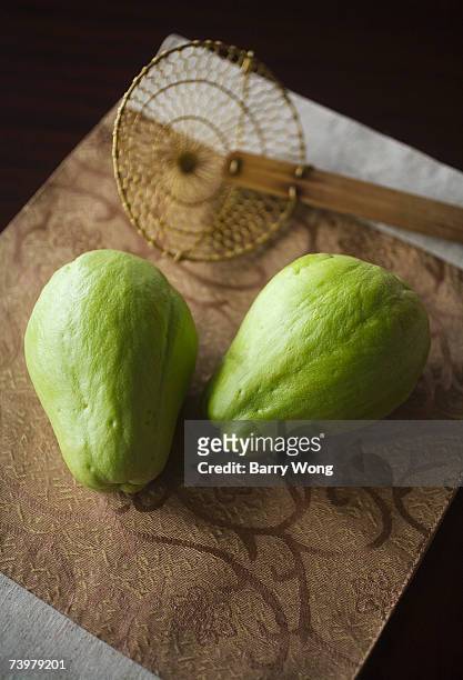 two chayote with. asian strainer in background, elevated view - straining spoon stock pictures, royalty-free photos & images