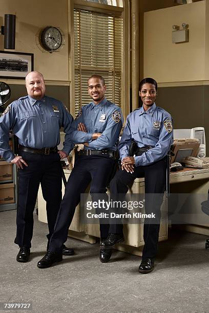 three police officers in police station, smiling, portrait - police station - fotografias e filmes do acervo