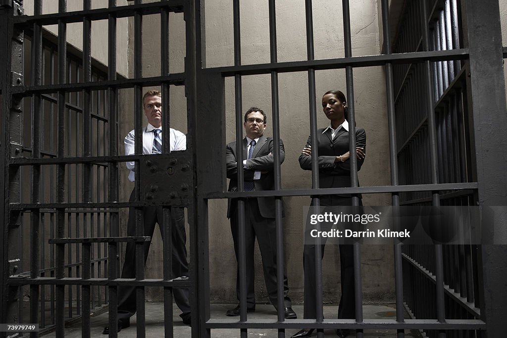 Woman and two men in prison cell, portrait