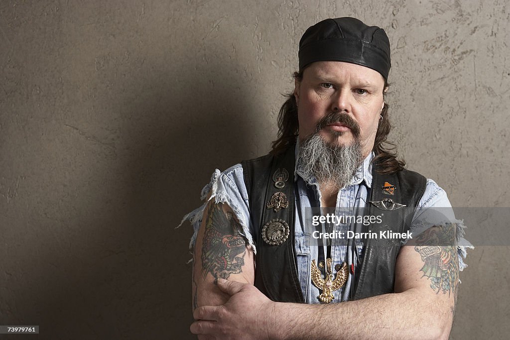 Male biker with tattoos on arms, portrait