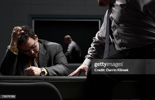 two men sitting at desk in interrogation room - interrogation room stock-fotos und bilder