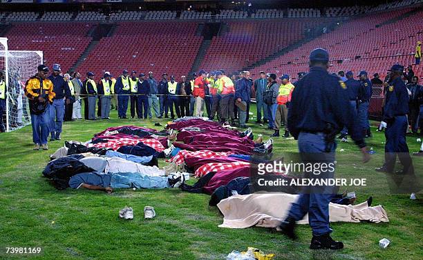 Johannesburg, SOUTH AFRICA: WITH AFP STORY BY MATSHELANE MAMABOLO SAFRICA-FBL-STADIUM-DISASTER Rescue services work around victims of a stampede 11...