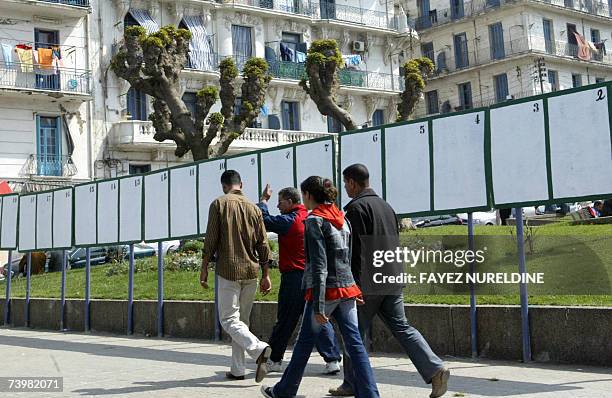 Local residents walk past empty electoral billborads in Algiers City, 26 April 2007. The official campaign for Parliamentary elections in Algeria...