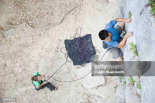 man climbing, woman belaying below - chalk bag stock pictures, royalty-free photos & images