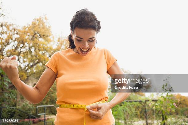 woman measuring waist - smiling woman waist up stock pictures, royalty-free photos & images