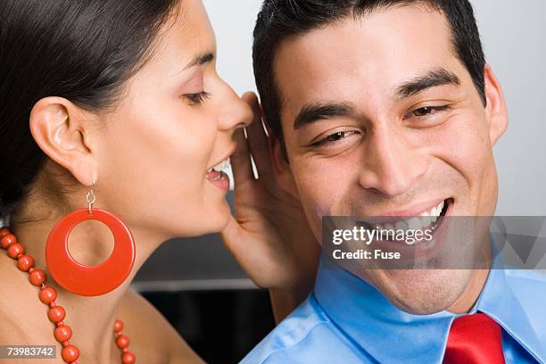 woman whispering to a man - earrings stock pictures, royalty-free photos & images