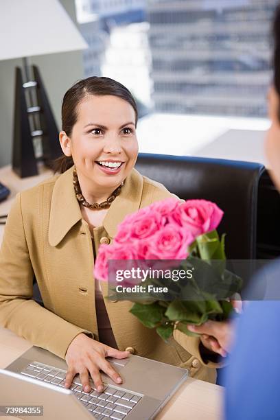 businessman giving businesswoman roses - administrative professionals day stockfoto's en -beelden