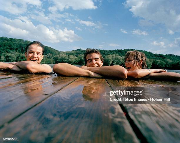 friends resting on a wooden jetty - jetty ストックフォトと画像