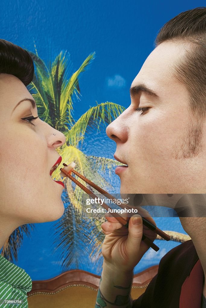 Man feeding sushi to his girlfriend