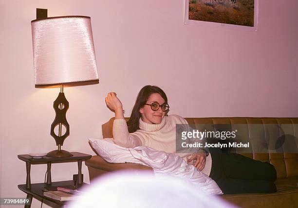a woman reclining on a sofa in a living room - 1970's long hair stock-fotos und bilder