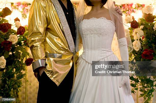 bride and groom standing together at the altar - goldene jacke stock-fotos und bilder