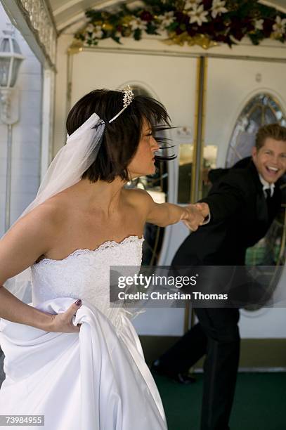 groom dragging bride into a wedding chapel - angry groom wedding photos et images de collection
