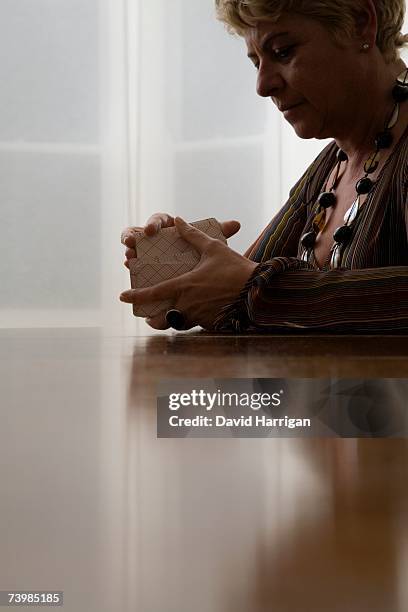 a woman shuffling tarot cards - fortune teller table stock pictures, royalty-free photos & images