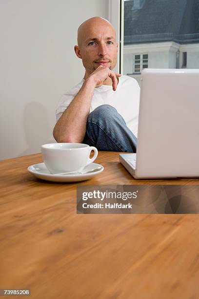 a man sitting at table with laptop and drink - mann ellbogen stock-fotos und bilder