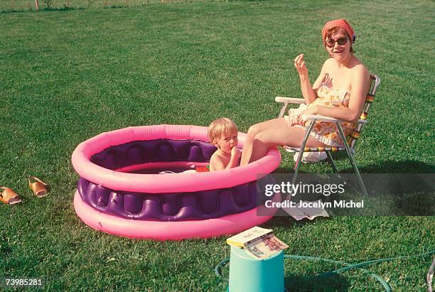mother and son together in a wading pool - swimming tube stockfoto's en -beelden