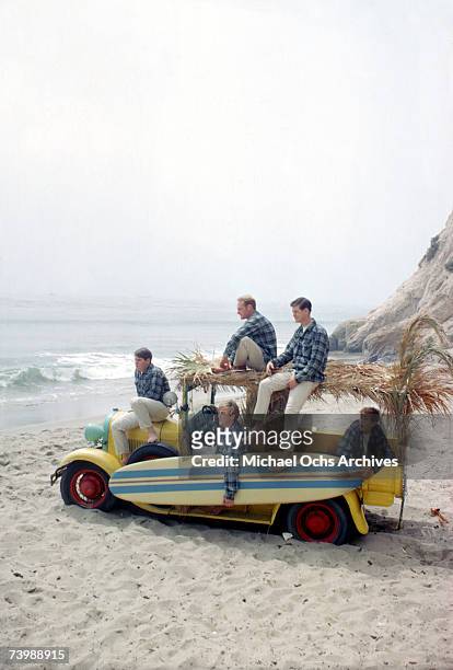 Rock and roll band "The Beach Boys" pose for a portrait with a vintage station wagon in August 1962 in Los Angeles, California. Carl Wilson, Mike...