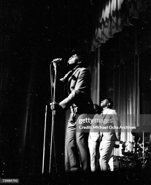 Soul singer James Brown performs onstage at the Apollo Theatre with the Famous Flames in 1964 in New York, New York.
