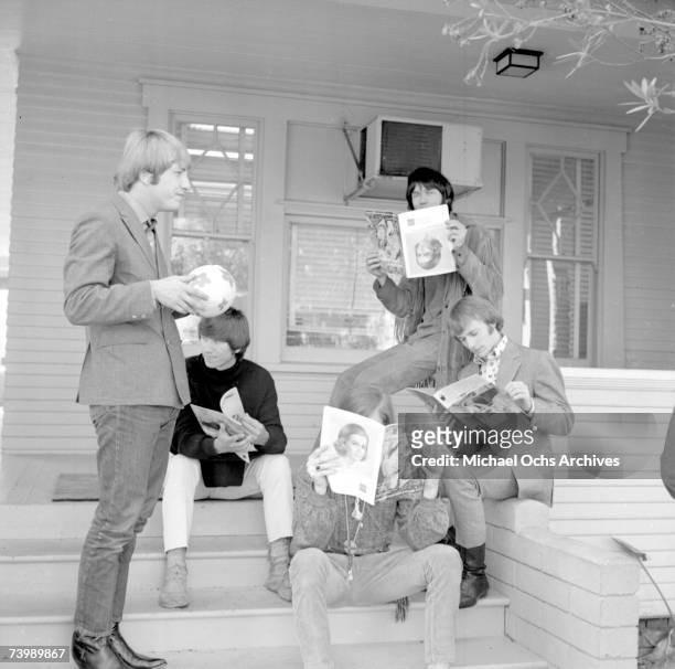 Superstar group "Buffalo Springfield" poses for a portrait sitting on their front porch holding copies of Teen Magazine in 1966 in Hollywood,...