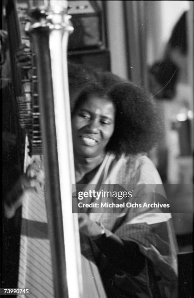 American jazz musician and composer Alice Coltrane , playing a harp, circa 1965.