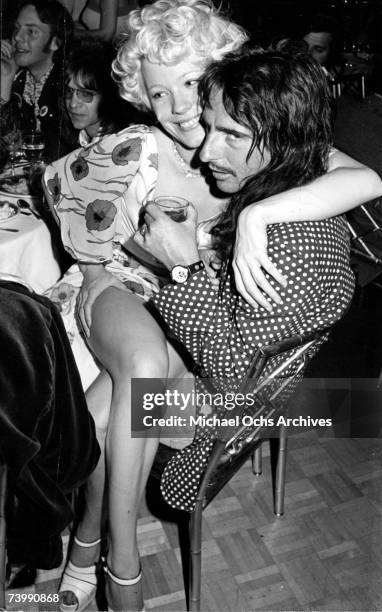 Alice Cooper with Pamela Des Barres and Rodney Bingenheimer in the background.