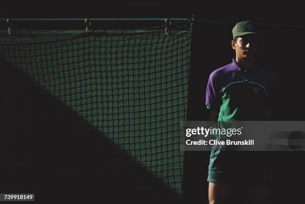 Ball boy stands in the shadows of a match during the Wimbledon Lawn Tennis Championships on 27 June 1995 at the All England Lawn Tennis and Croquet...