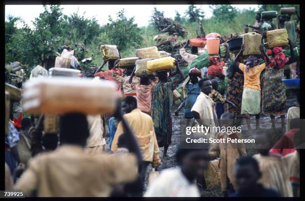 Crowd of refugees carry their belongings May 3, 1994 at the border of Rwanda and Tanzania. Hutu refugees have fled to Tanzania border across the...