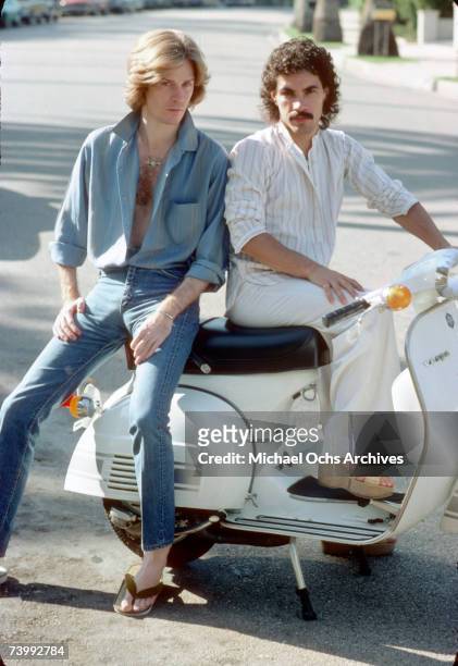 Musicians and singers Daryl Hall and John Oates of the rock duo Hall & Oates pose for a portrait on a Vespa scooter in June 1976 in Los Angeles,...