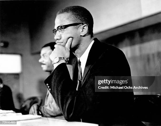 Civil rights leader Malcolm X attends a meeting in preparation for a school boycott at E.117th Street in Harlem on March 15, 1964 in New York City,...