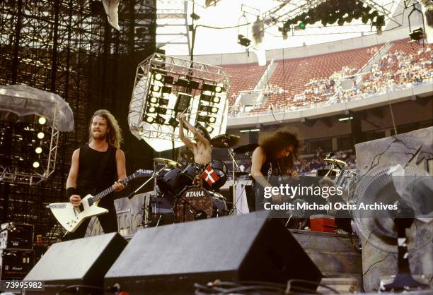 Guitarists James Hetfield and Kirk Hammett and drummer Lars Ulrich of the heavy metal quartet "Metallica" perform onstage at the "Monsters of Rock"...