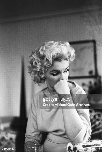 Actress Marilyn Monroe relaxes on a couch in her hotel room at the Ambassador Hotel on March 24, 1955 in New York City, New York.