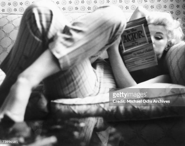 Actress Marilyn Monroe reads the book "To the Actor: On the Technique of Acting" by Michael Chekhov in a quiet moment at the Ambassador Hotel in...