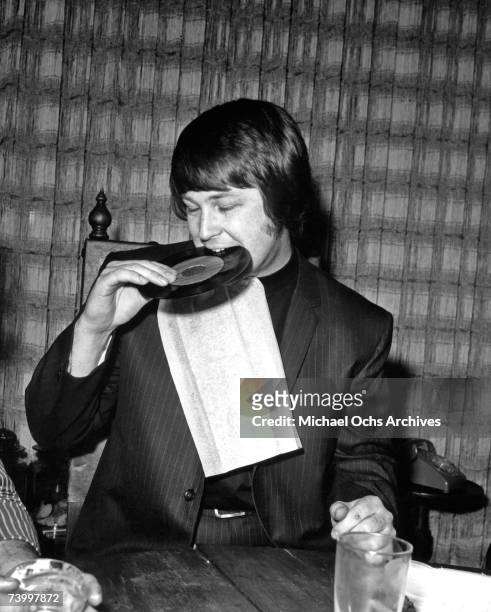 Band leader Brian Wilson of the rock and roll band "The Beach Boys" chomps variously down on a record, a shoe, other people's food, a pepper grinder...