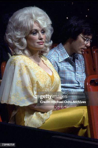 Country singer Dolly Parton attends an event wearing a yellow dress in circa 1975 in Los Angeles, California.