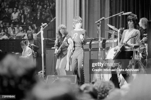 Rock and roll band "The Rolling Stones" perform onstage as photographer Annie Leibovitz looks on at Madison Square Garden in a concert that was...