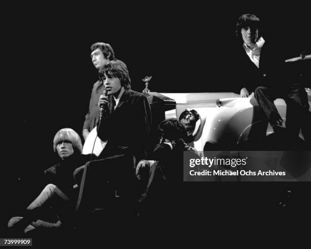 Rock and roll band 'The Rolling Stones' performs onstage on a TV show leaning against a Rolls Royce in 1965. Brian Jones, Charlie Watts, Mick Jagger,...