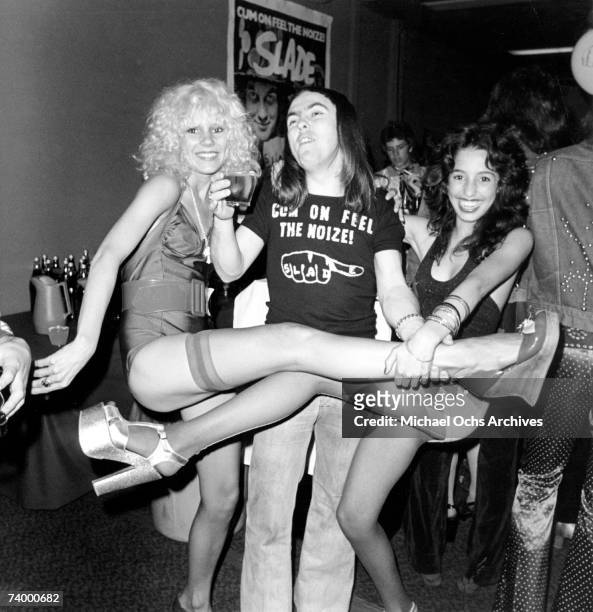 Groupie Sable Starr, guitarist in the rock and roll band Slade Dave Hill and groupie Lori Maddox pose for a portrait in June 1973 in Los Angeles,...