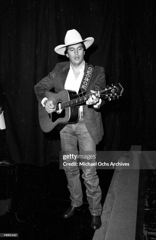 George Strait Rodeo Portrait Country musician George Strait poses for a portrait holding a Guild ...