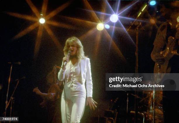 Welsh singer Bonnie Tyler performing on stage, circa 1980. She is wearing a white suit.