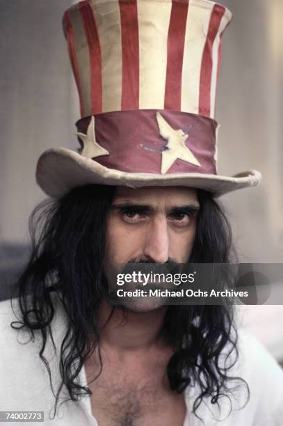 Rock and roll guitar player Frank Zappa poses for a portrait wearing an Uncle Sam stars & stripes top hat in March 1979 in Los Angeles, California.