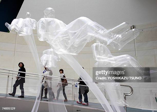 Human-shaped plastic balloons fitted with ultra-light-weight super-organza fabric clothes, float in the air installed by contemporary artist Yasuhiro...