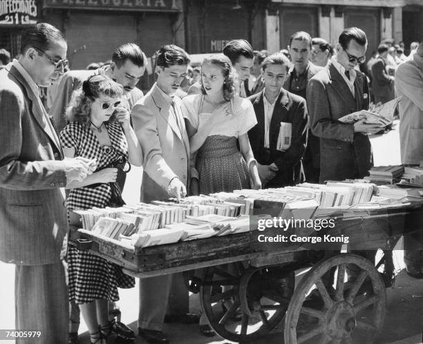 Shoppers at a book stall in El Rastro, a sunday street market in Madrid, 22nd June 1950.