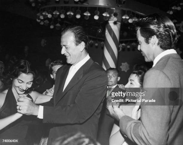 American actor John Wayne with his wife Pilar Palette, and actor Rory Calhoun with his wife Lita Baron at the Mocambo nightclub in West Hollywood,...