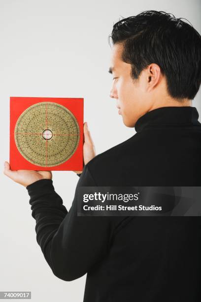 asian man holding feng shui chart - feng shui 個照片及圖片檔