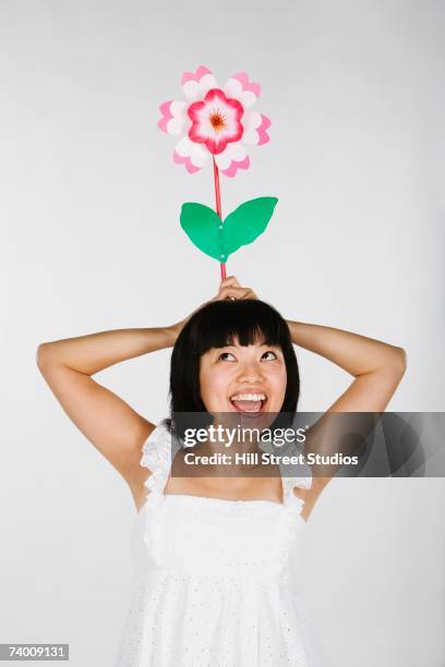 asian woman holding flower over head - hill street studios bildbanksfoton och bilder