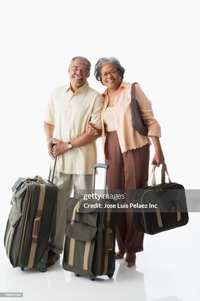 Portrait of senior African couple carrying luggage