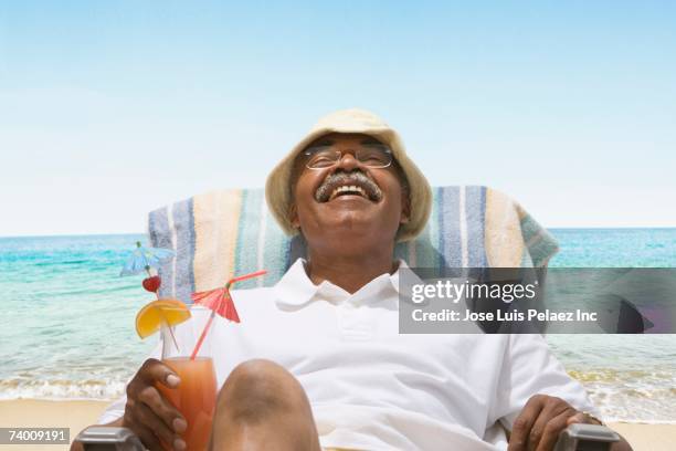 senior african man relaxing in beach chair - idyllic retirement stock pictures, royalty-free photos & images