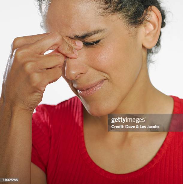 hispanic woman squeezing bridge of nose - frontal sinus stock pictures, royalty-free photos & images
