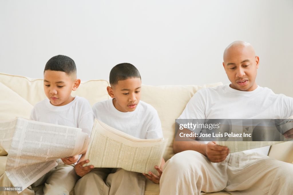 Indian father and sons reading newspaper