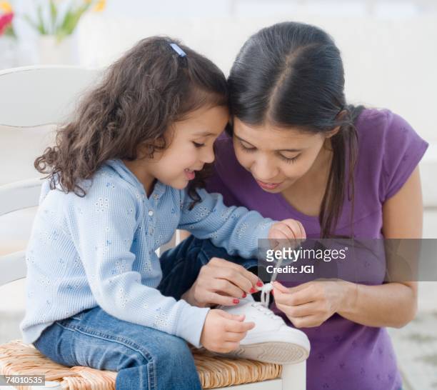 hispanic mother helping daughter tie shoe - amarrar o cadarço - fotografias e filmes do acervo